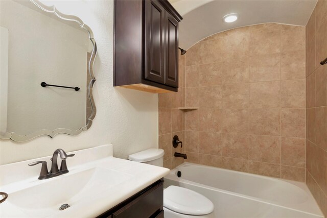 bathroom featuring vanity, washtub / shower combination, and toilet
