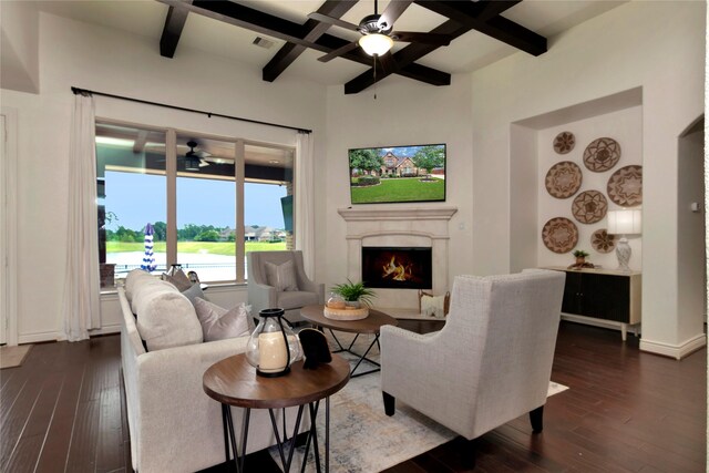 living room with a ceiling fan, coffered ceiling, dark wood finished floors, and a lit fireplace