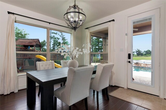 dining room with an inviting chandelier and dark wood-type flooring