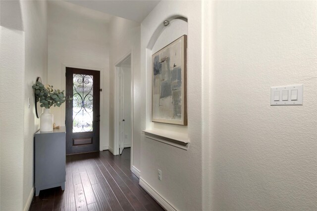 entryway featuring baseboards and dark wood-type flooring