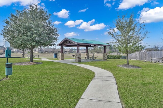view of community with a lawn, fence, and a gazebo