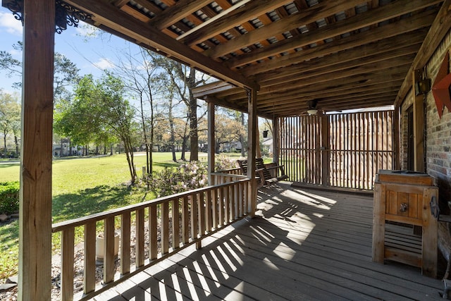 wooden terrace with a ceiling fan and a lawn