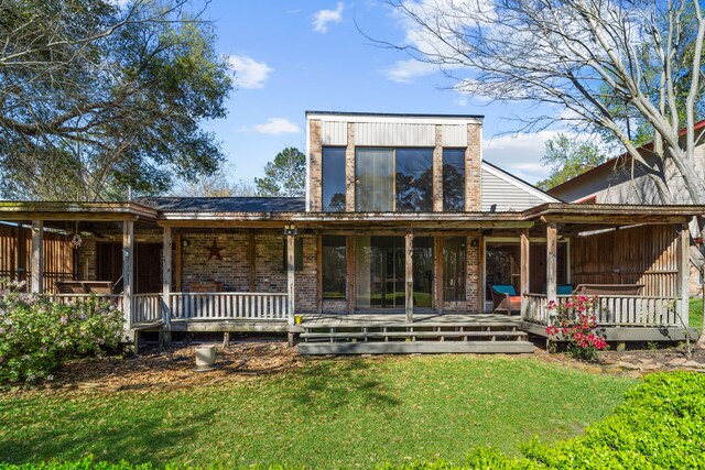 back of property featuring brick siding, covered porch, and a lawn