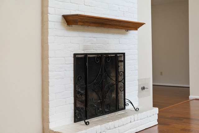 details with baseboards, wood finished floors, and a fireplace