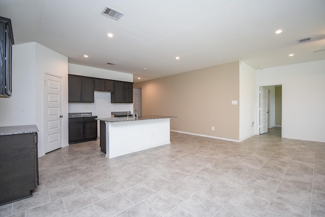 kitchen featuring visible vents, baseboards, recessed lighting, a kitchen island with sink, and open floor plan