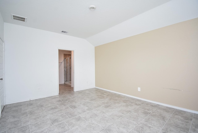 unfurnished room with visible vents, lofted ceiling, and baseboards