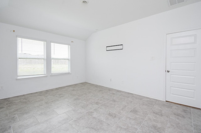 unfurnished room with visible vents, baseboards, and vaulted ceiling