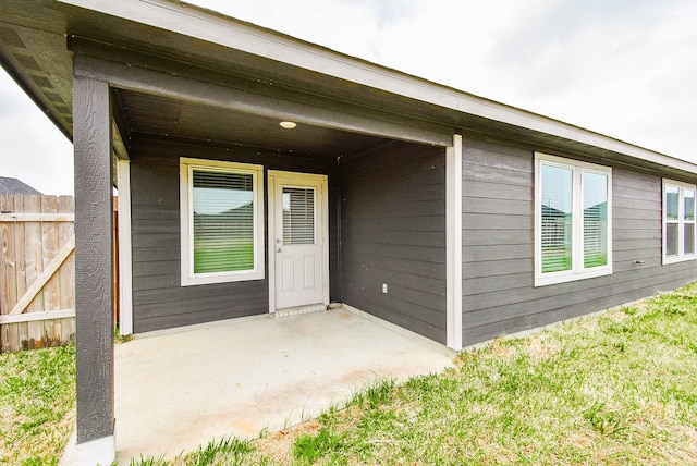 property entrance with fence and a patio area