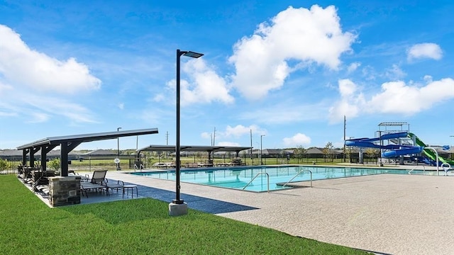 community pool with a gazebo, a lawn, a water slide, and a patio