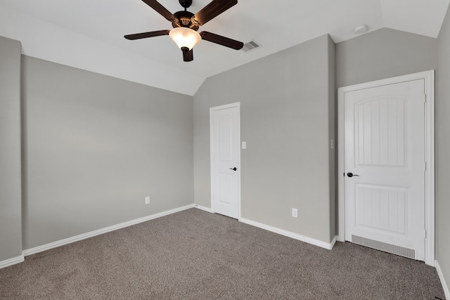 unfurnished bedroom featuring visible vents, ceiling fan, baseboards, vaulted ceiling, and carpet flooring