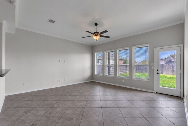 interior space with tile patterned floors, visible vents, a ceiling fan, crown molding, and baseboards