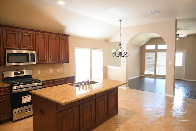 kitchen with visible vents, lofted ceiling, decorative backsplash, stainless steel appliances, and a sink