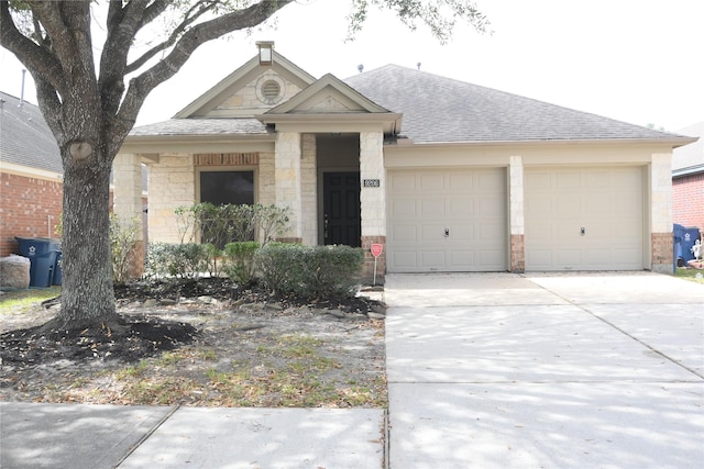 view of front of property featuring a garage, stone siding, driveway, and a shingled roof