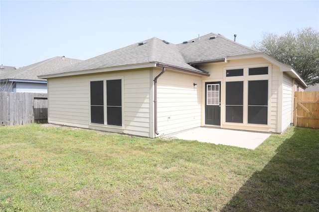 rear view of house with a yard, a patio, a fenced backyard, and a shingled roof