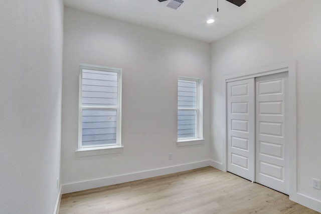 unfurnished bedroom featuring visible vents, a closet, light wood finished floors, baseboards, and ceiling fan