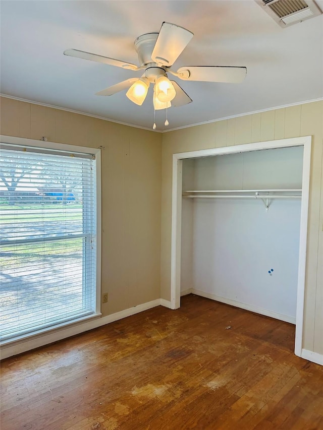 unfurnished bedroom with visible vents, crown molding, and hardwood / wood-style floors