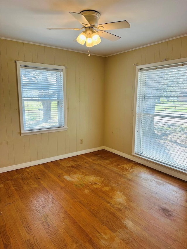 spare room featuring hardwood / wood-style flooring, baseboards, and ceiling fan