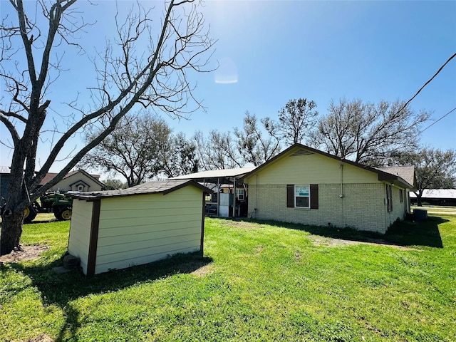 back of house featuring a yard and brick siding