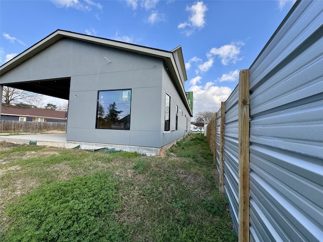 view of home's exterior with fence and a lawn