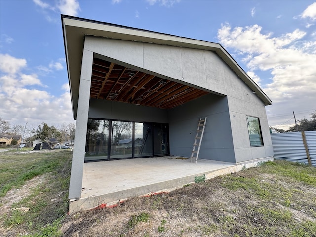 rear view of property featuring fence and a patio area