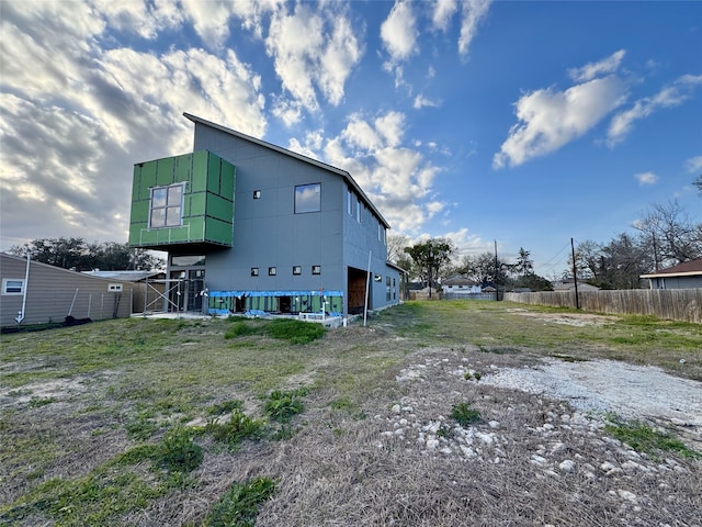 rear view of property featuring fence