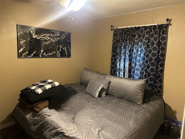 bedroom featuring a textured wall and a textured ceiling