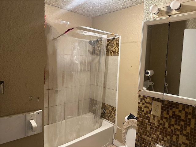 bathroom with shower / bathing tub combination, a textured wall, and a textured ceiling