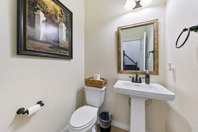 half bath with toilet and baseboards