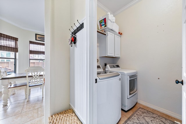 laundry area featuring crown molding, cabinet space, baseboards, separate washer and dryer, and light tile patterned flooring