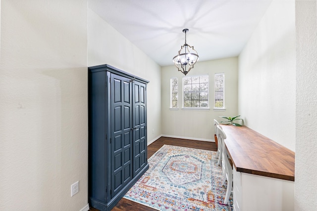 entryway with baseboards, dark wood-style flooring, and a notable chandelier