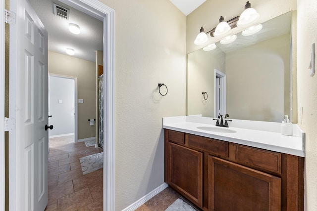 full bathroom with vanity, baseboards, and visible vents