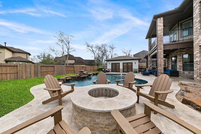 view of swimming pool with a fenced in pool, an outdoor structure, a fenced backyard, an outdoor fire pit, and a patio