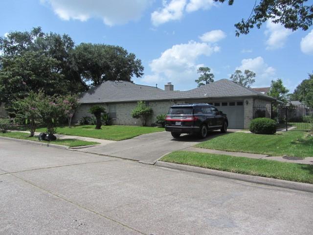 single story home featuring a front yard, concrete driveway, fence, and a garage