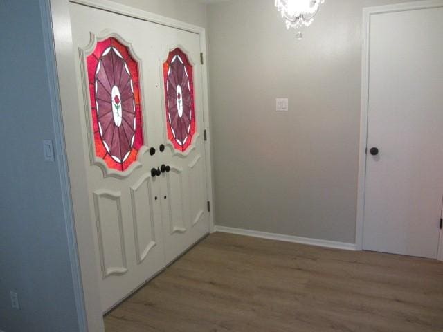 foyer entrance featuring baseboards and wood finished floors