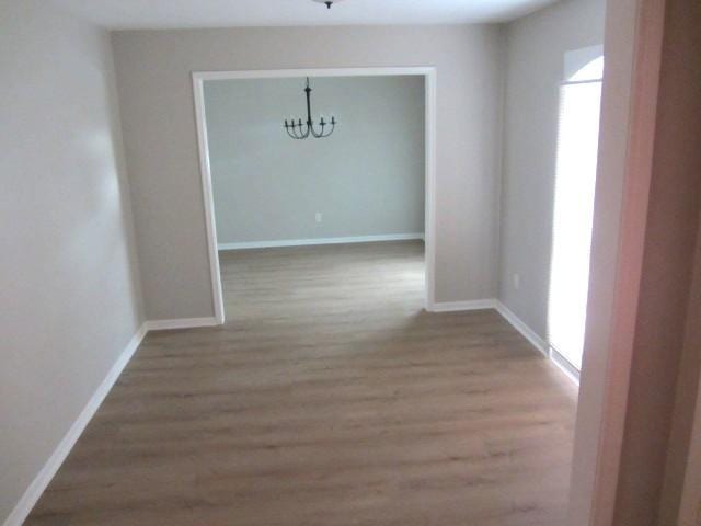 unfurnished dining area featuring baseboards and wood finished floors