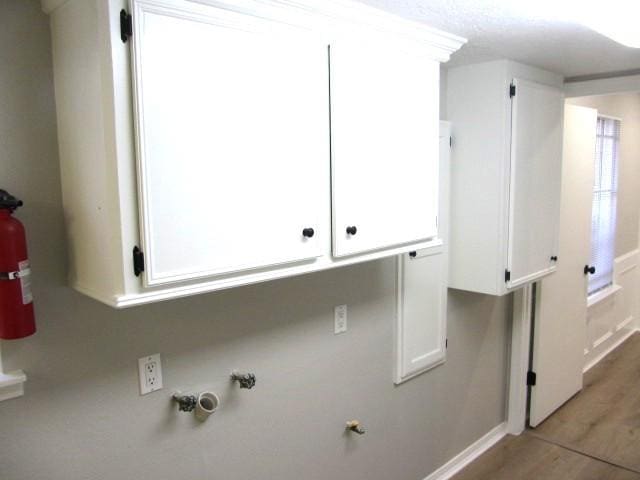 clothes washing area featuring light wood-style floors and gas dryer hookup