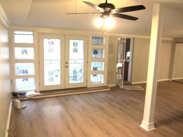 interior space featuring ceiling fan, french doors, baseboards, and wood finished floors