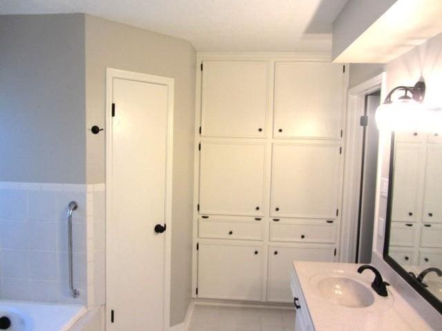 full bathroom featuring vanity, a tub to relax in, and tile patterned flooring