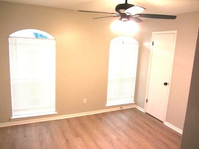 unfurnished room featuring baseboards, ceiling fan, and wood finished floors