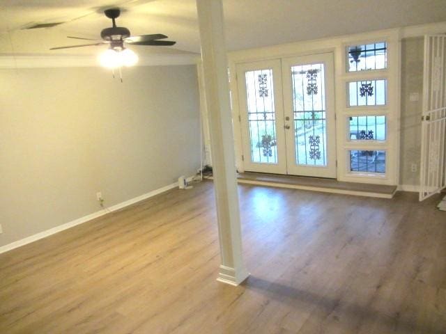 unfurnished room with french doors, baseboards, a ceiling fan, and wood finished floors