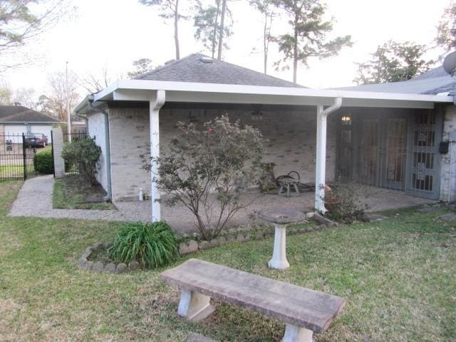 view of side of property with a patio area, a lawn, and fence