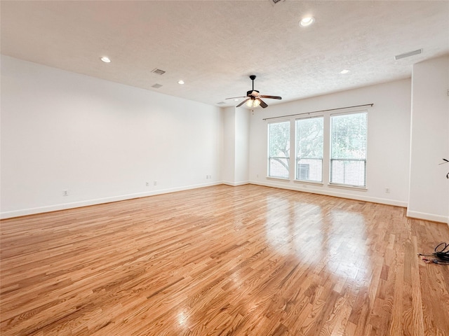 spare room featuring a ceiling fan, recessed lighting, light wood-style floors, and baseboards