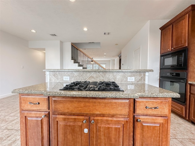 kitchen with light tile patterned floors, decorative backsplash, black appliances, and visible vents