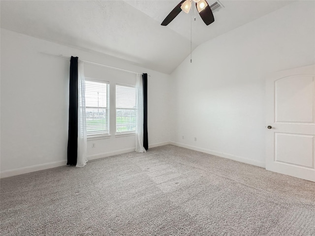 carpeted spare room with visible vents, baseboards, ceiling fan, and vaulted ceiling