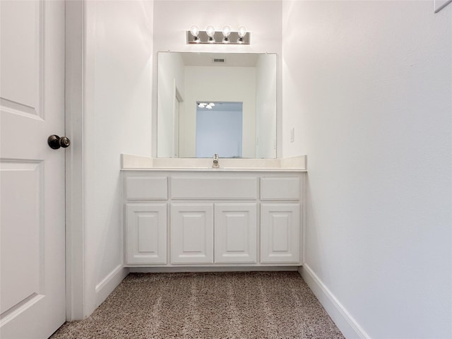 bathroom featuring visible vents, vanity, and baseboards