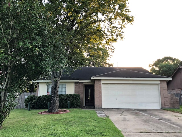 ranch-style house with a front yard, fence, driveway, a garage, and brick siding