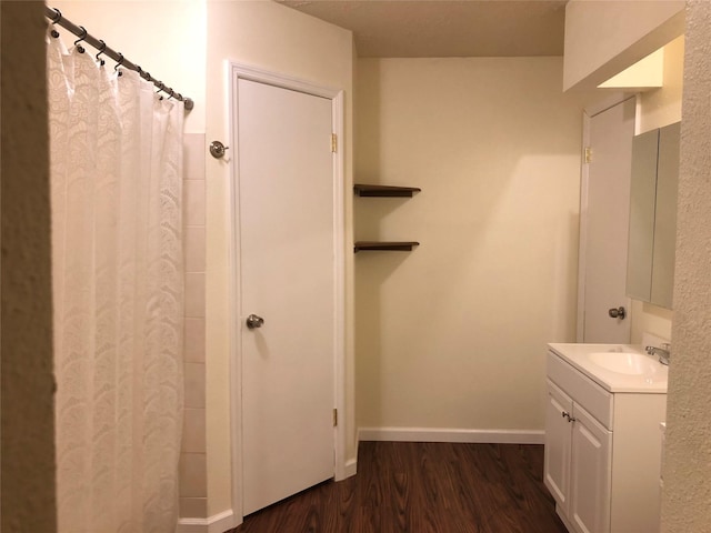 bathroom featuring baseboards, a shower with curtain, wood finished floors, and vanity