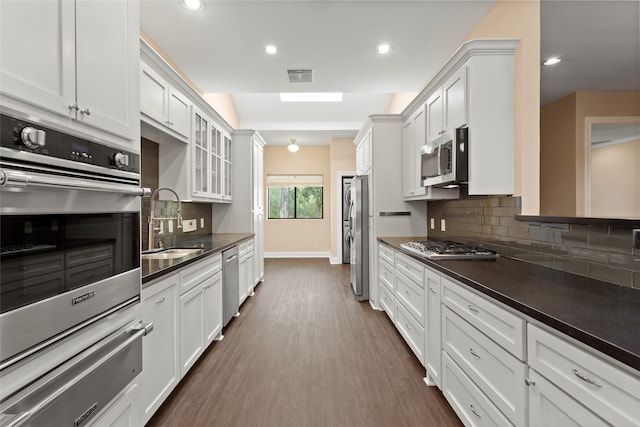 148 Sugarberry Cir, Houston, TX 77024 - kitchen with visible vents, dark countertops, a sink, appliances with stainless steel finishes, and a warming drawer