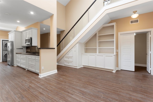 148 Sugarberry Cir, Houston, TX 77024 - bonus room featuring stairs, stacked washing maching and dryer, wood finished floors, and visible vents