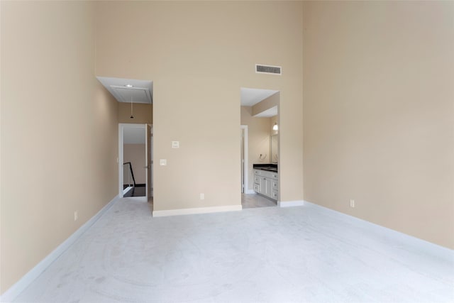 148 Sugarberry Cir, Houston, TX 77024 - spare room featuring light colored carpet, attic access, baseboards, a towering ceiling, and visible vents
